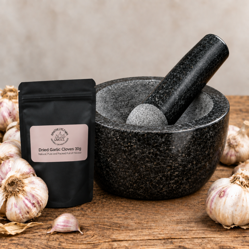 Black granite pestle and mortar styled with fresh garlic and Nant Helyg Farm dried garlic cloves